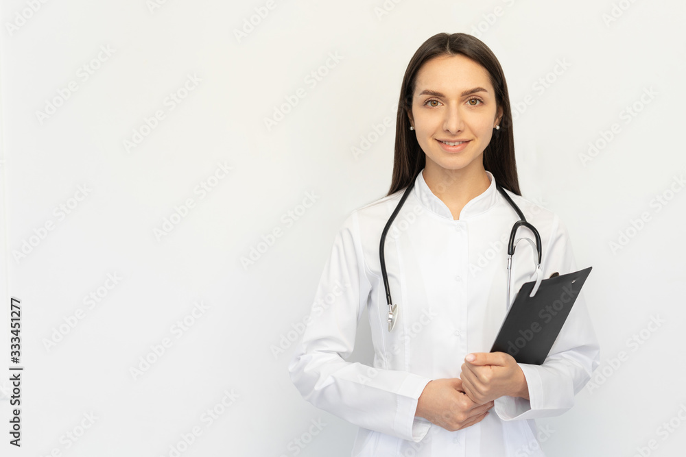 Friendly female doctor smiling holding a folder in her hands, a stethoscope on her neck Friendly female doctor smiling holding a folder in her hands, a stethoscope on her neck