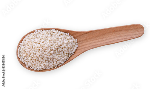 White sesame seeds in a wooden spoon isolated on a white background. Top view.