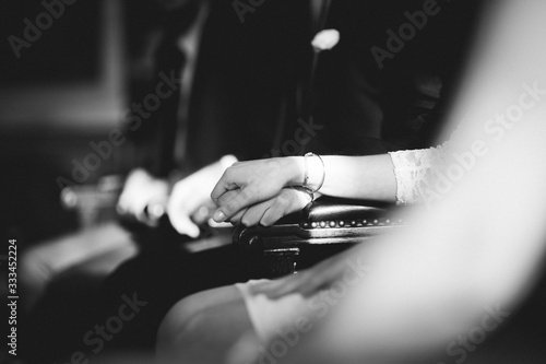 wedding couples hands holding at the cerenomy, sitting inside registry office photo