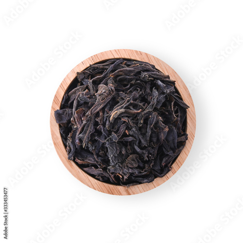 Dried tea leaves in a wooden cup Isolated on a white background. top view.