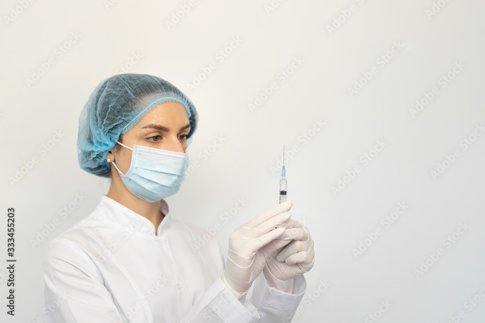 Female doctor in a protective medical mask and gloves with a syringe Female doctor in a protective medical mask and gloves with a syringe