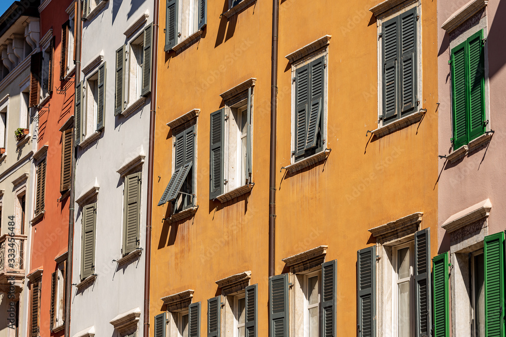 Facade of generic houses with many windows and shutters in a street in Trentino Alto Adige, Italy, Europe