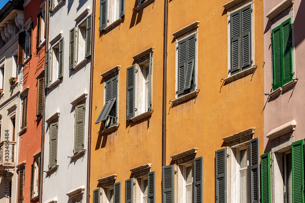 Facade of generic houses with many windows and shutters in a street in Trentino Alto Adige, Italy, Europe Facade of generic houses with many windows and shutters in a street in Trentino Alto Adige, Italy, Europe