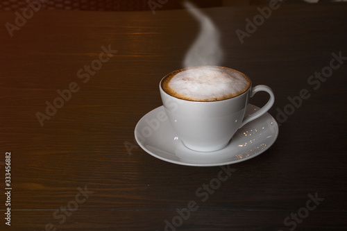 cup of cappuccino coffee on wooden background