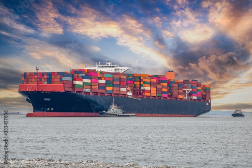 Container ships in the export and import business and logistics. Enter the dock by towing boat.