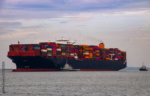 Container ships in the export and import business and logistics. Enter the dock by towing boat.