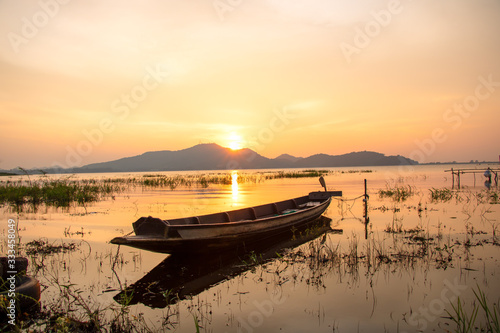 beautiful sunset sky and wood boat floating in bangpra water reservoir lake chonburi eatern of thailand photo