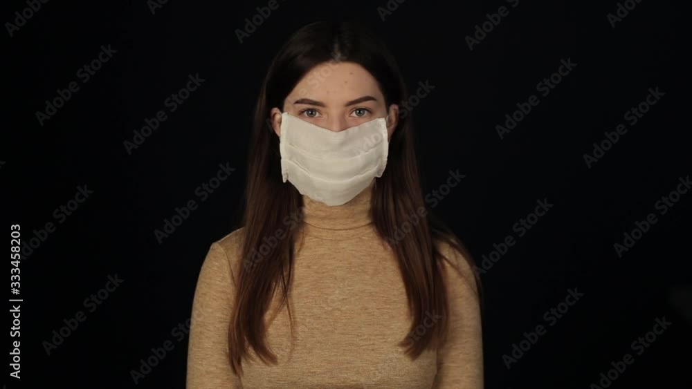 charming girl putting on a medical protective mask against coronavirus. Covid-19 defense charming girl putting on a medical protective mask against coronavirus. Covid-19 defense