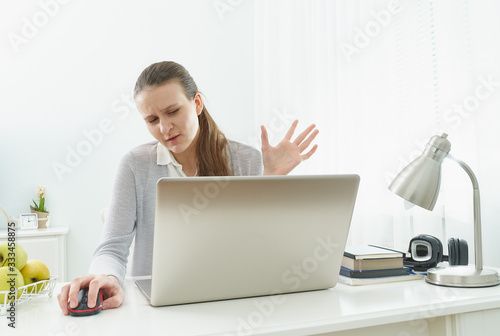 Girl listens or looks at information on computer with disbelief. Skeptical expression. Fake news.