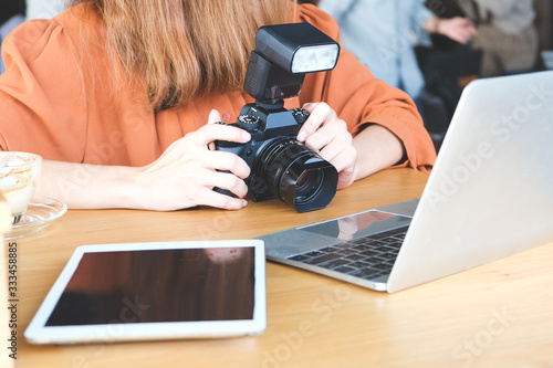 Woman preparing to load images from camera to computer and tablet After shooting