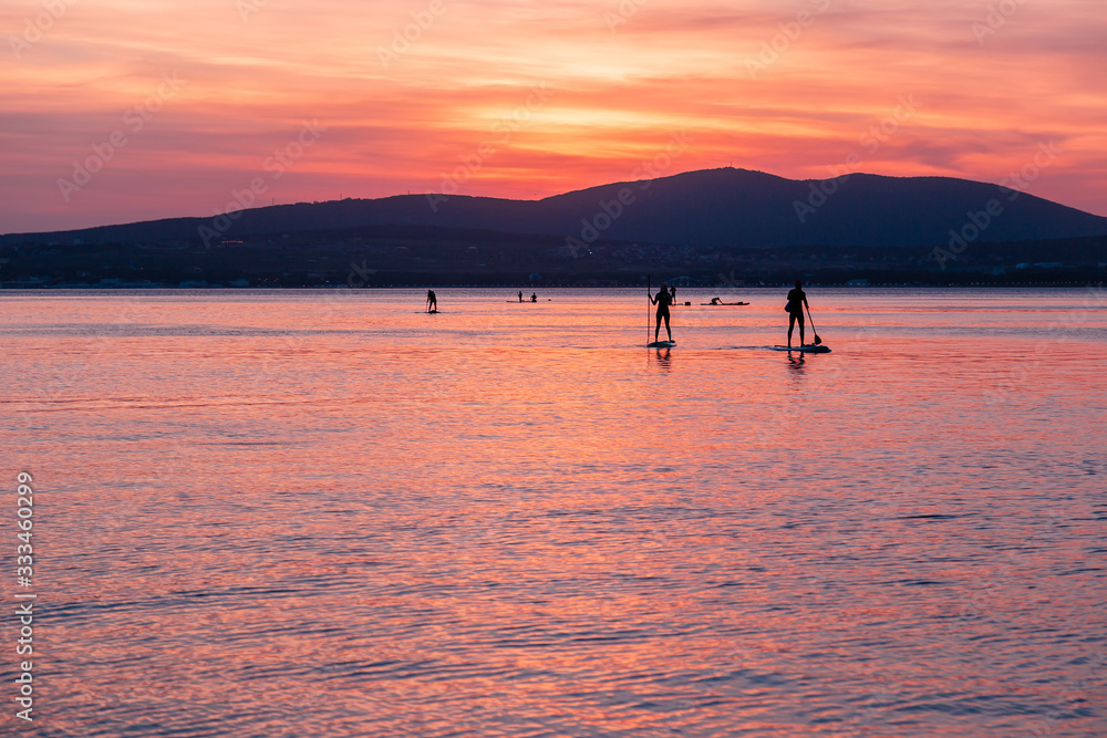 Fototapeta premium SAP surfing at sunset in Gelendzhik, Krasnodar region.