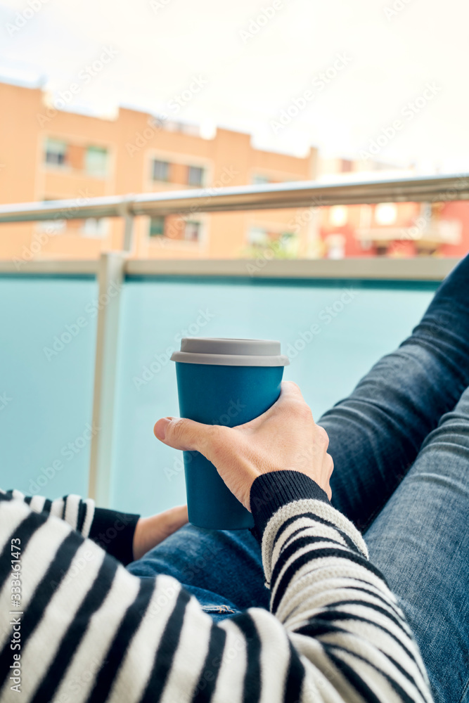 young man having a coffee in the balcony young man having a coffee in the balcony