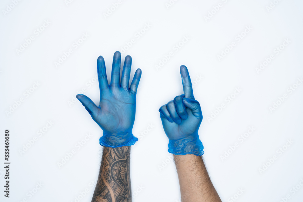 Obraz premium A man hand and gestures in Blue rubber glove shows six finger sign isolated on white background.