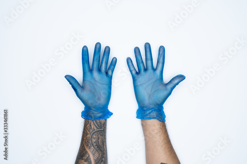 A man hand and gestures in Blue rubber glove shows ten finger sign isolated on white background.