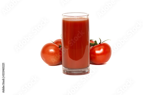 a glass of tomato juice and red, ripe tomatoes on a fresh lettuce leaf, isolated on a white background