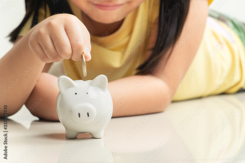 Saving and business concept, Cute girl with piggy bank and coins at home Saving and business concept, Cute girl with piggy bank and coins at home