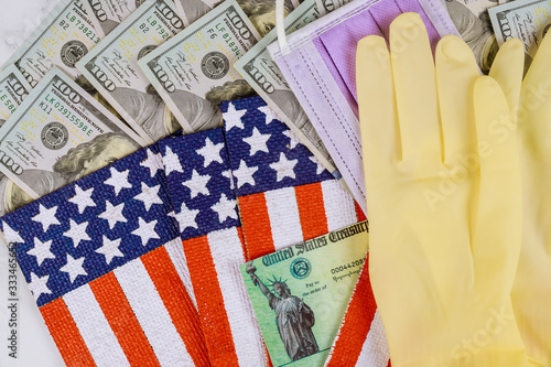 Federal monetary assistance stimulus U.S. economic tax return check USA dollar cash banknote on American flag Global pandemic Covid 19 lockdown
