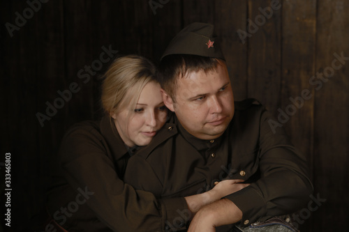 Portrait couple in military uniforms from the second world war young woman and man with accordion sit in embrace