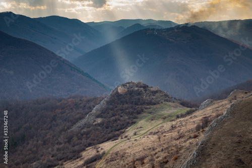 epic landscape with ruins of a castle and heavenly lights at sunset. Liteni fortress in Transylvania.