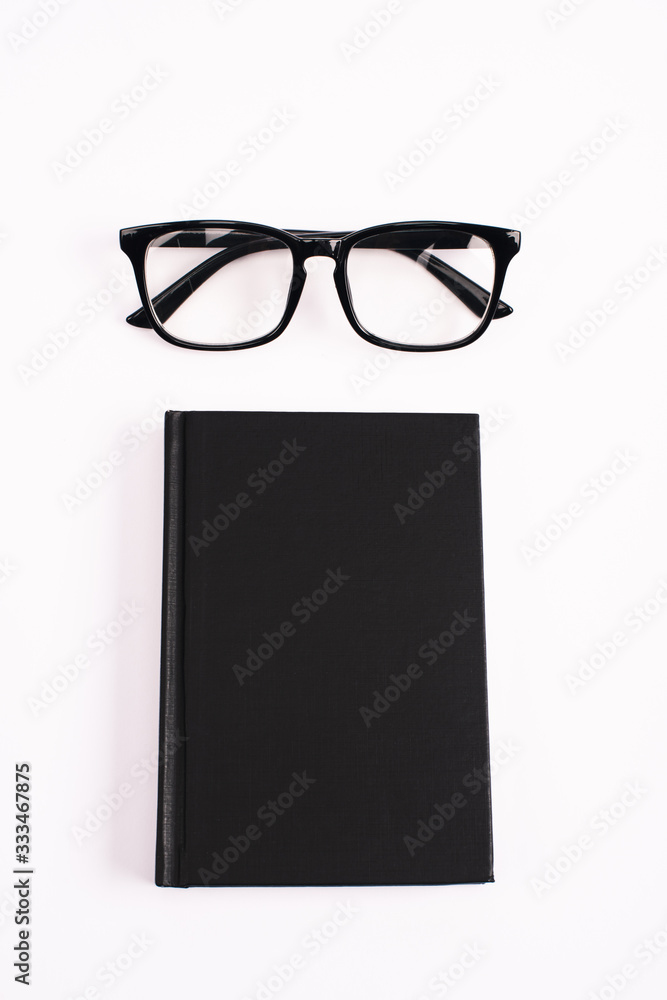top view of glasses and black notebook isolated on white top view of glasses and black notebook isolated on white