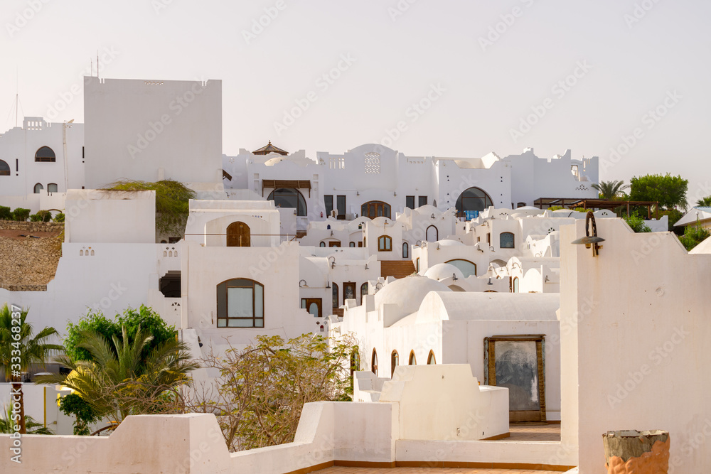 Sharm El Sheikh, Egypt - March 07, 2020: White cascading buildings of an old Arab town . Empty hotel complex in Oriental style. An abandoned resort without tourists.