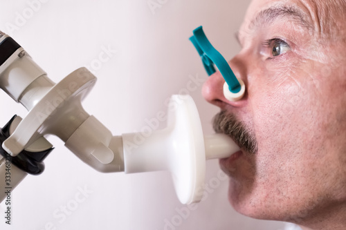 Canvas Print Senior hispanic man man testing breathing function by spirometry.