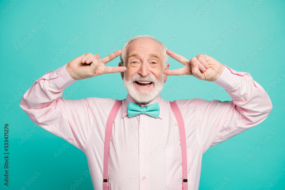 Portrait of dreamy candid old man enjoy free time rest relax make v-signs wear pink good look outfit isolated over teal color background