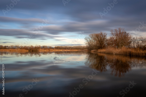 Pond Vrkoc - colorful sunset at the pond, reeds and mature trees on the edges. © Jana Krizova