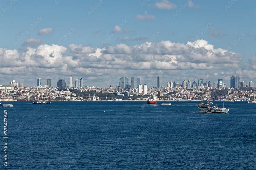 The various Passenger Ferries crossing the Bosphorus Straits at the City of Istanbul in front of a Vessel in transit through the Straits.