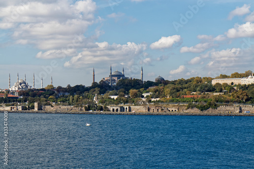 The tree lined grounds of the Topkapi Palace with its fortified walls along the shoreline of the Bosphorus Straits.