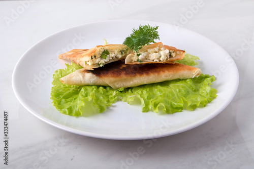 Pita triangles with cottage cheese, herbs, on a white plate