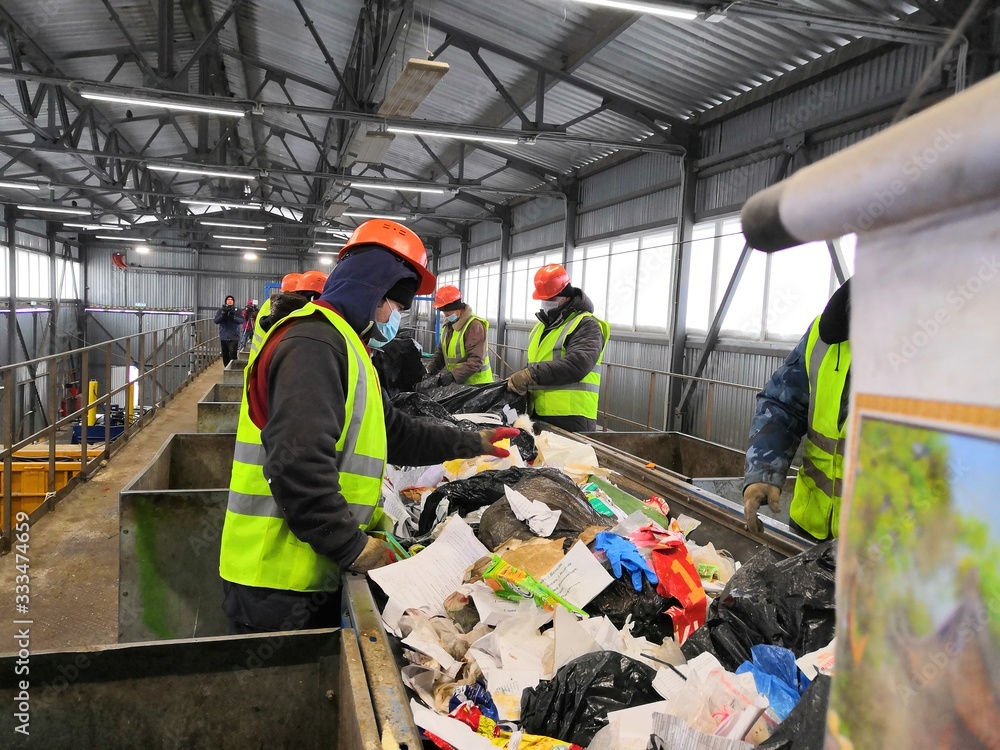 Fototapeta premium people in yellow vests sort out garbage