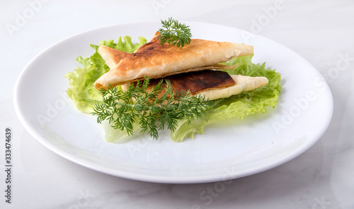 Pita triangles with cottage cheese, herbs, on a white plate