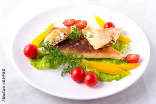 Pita triangles with cottage cheese, herbs, tomatoes on a white plate