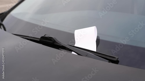 Police officer is writing parking ticket and put on windshield