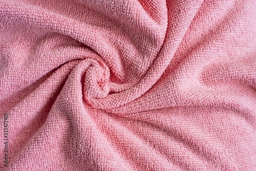 Wrinkled light pink microfiber cloth texture of microfiber towel closeup. pink microfiber cloth for cleaning objects and surfaces. Hygienic cleaning towel. fabric background.