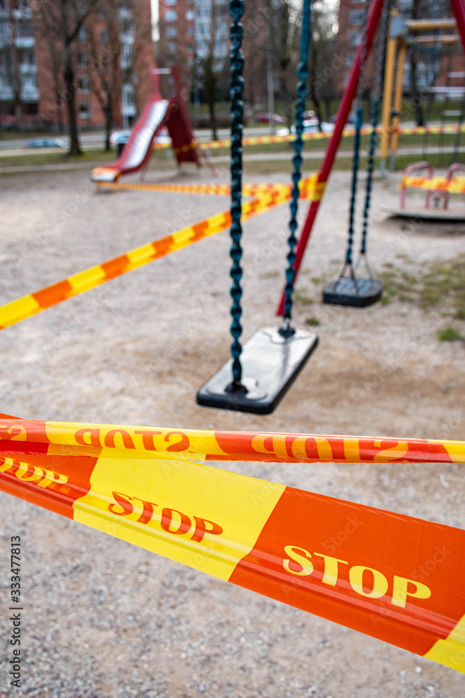 Park kids and children playground for game and activity empty and closed for Coronavirus or Covid19, slide and swing empty tape and strips with word STOP, do not enter, warning sign of quarantine Park kids and children playground for game and activity empty and closed for Coronavirus or Covid19, slide and swing empty tape and strips with word STOP, do not enter, warning sign of quarantine