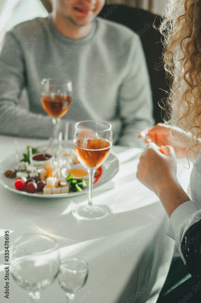 Romantic dinner for a couple on Saint Valentine's day: two glasses of cold white wine and gourmet french cheese plate Romantic dinner for a couple on Saint Valentine's day: two glasses of cold white wine and gourmet french cheese plate