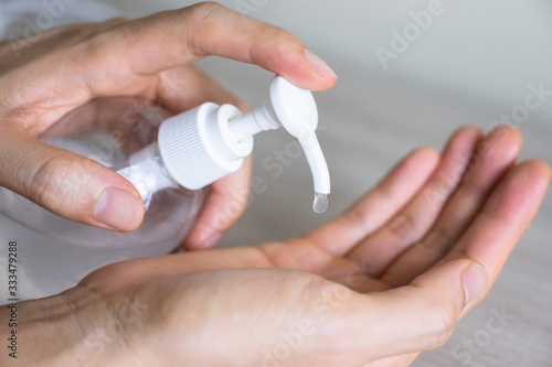 Man washing hands with sanitizer gel bottle or soap for coronavirus prevention  hygiene to stop spreading covid-19  select focus 
