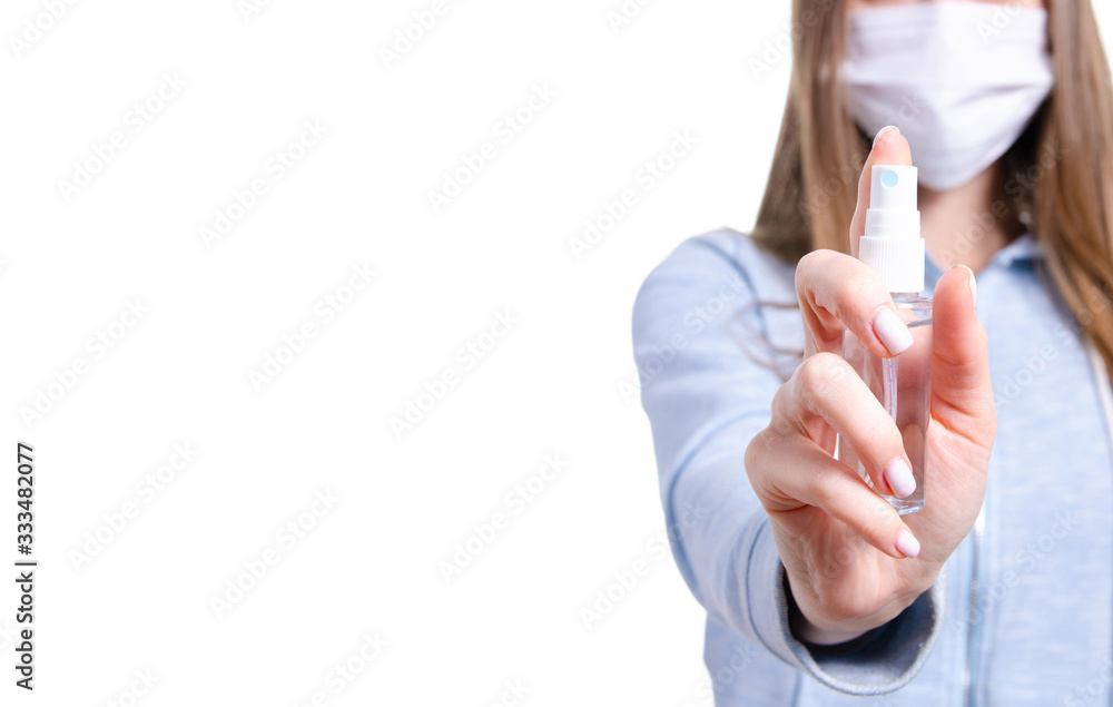 Woman in medical protective mask holding antiseptic disinfection virus on white background isolation Woman in medical protective mask holding antiseptic disinfection virus on white background isolation