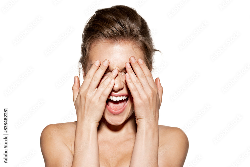 Funny girl with healthy clean skin covering face with hands Funny girl with healthy clean skin covering face with hands
