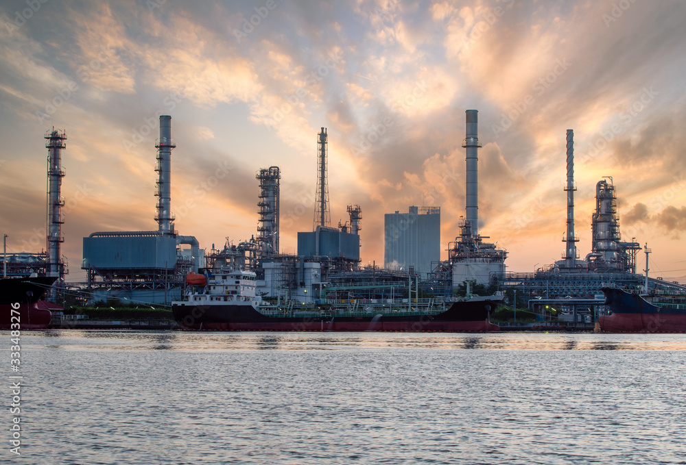 View of petrochemical plants and oil refineries, natural gas storage tanks, industrial along with the sky at sunset, oil transportation by boat View of petrochemical plants and oil refineries, natural gas storage tanks, industrial along with the sky at sunset, oil transportation by boat