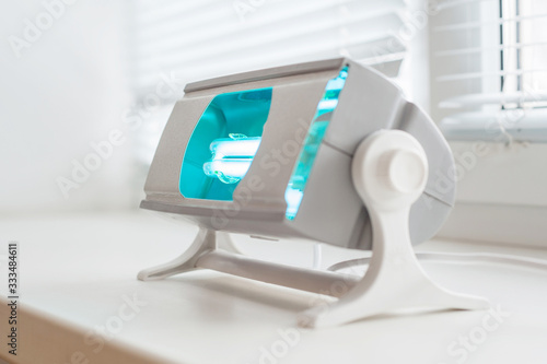 A working ultraviolet lamp on a white background. The concept of protecting and cleaning rooms and objects from bacteria and viruses. Medicine and healthcare.