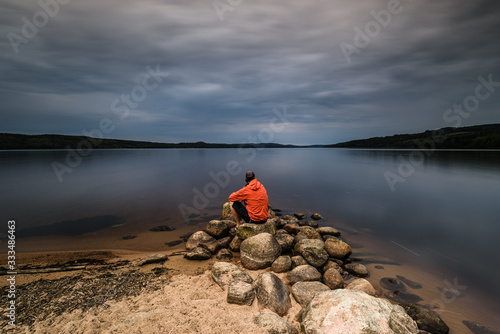 Man sitting alone at lake, Sweden.