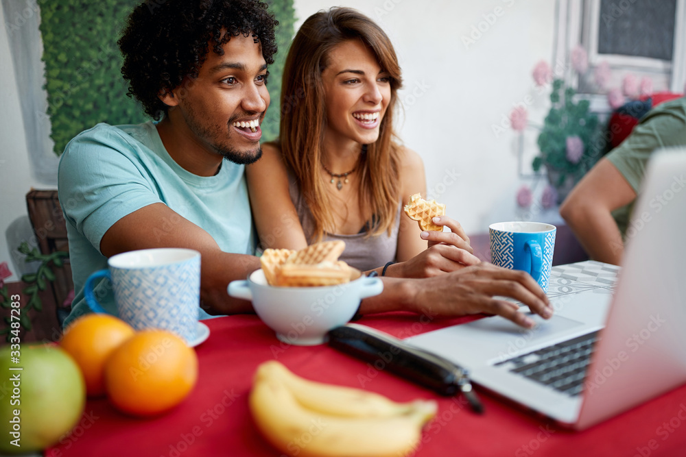 Happy male and female looking et laptop Happy male and female looking et laptop