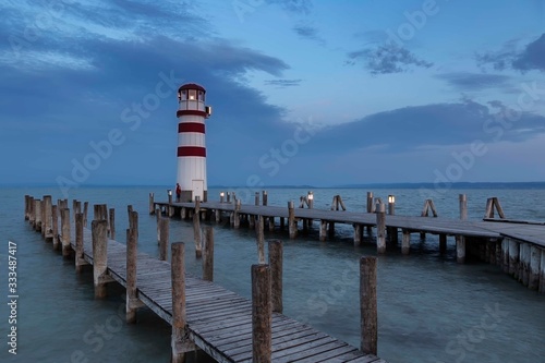Neusiedl am See - Lake Neusiedl  wooden pier lined with lights and leading to a white-red lighthouse at sunrise