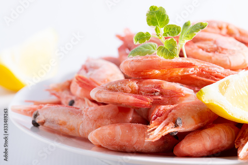 Fresh organic shrimps with lemon and aromatic herbs on the plate macro view. Sea food, healthy diet food concept.