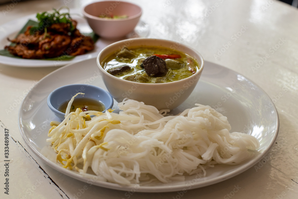 Green curry with khanom chin and fish cake over the table Green curry with khanom chin and fish cake over the table