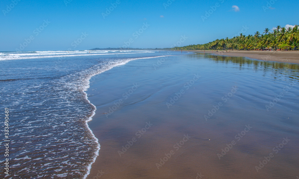 Sandstrand von Uvita mit sanften Wellen an der Pazifikküste von Costa Rica