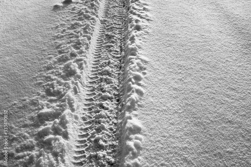 Obraz na płótnie The footprint of a car wheel in the snow. The road in the winter time. w salonie